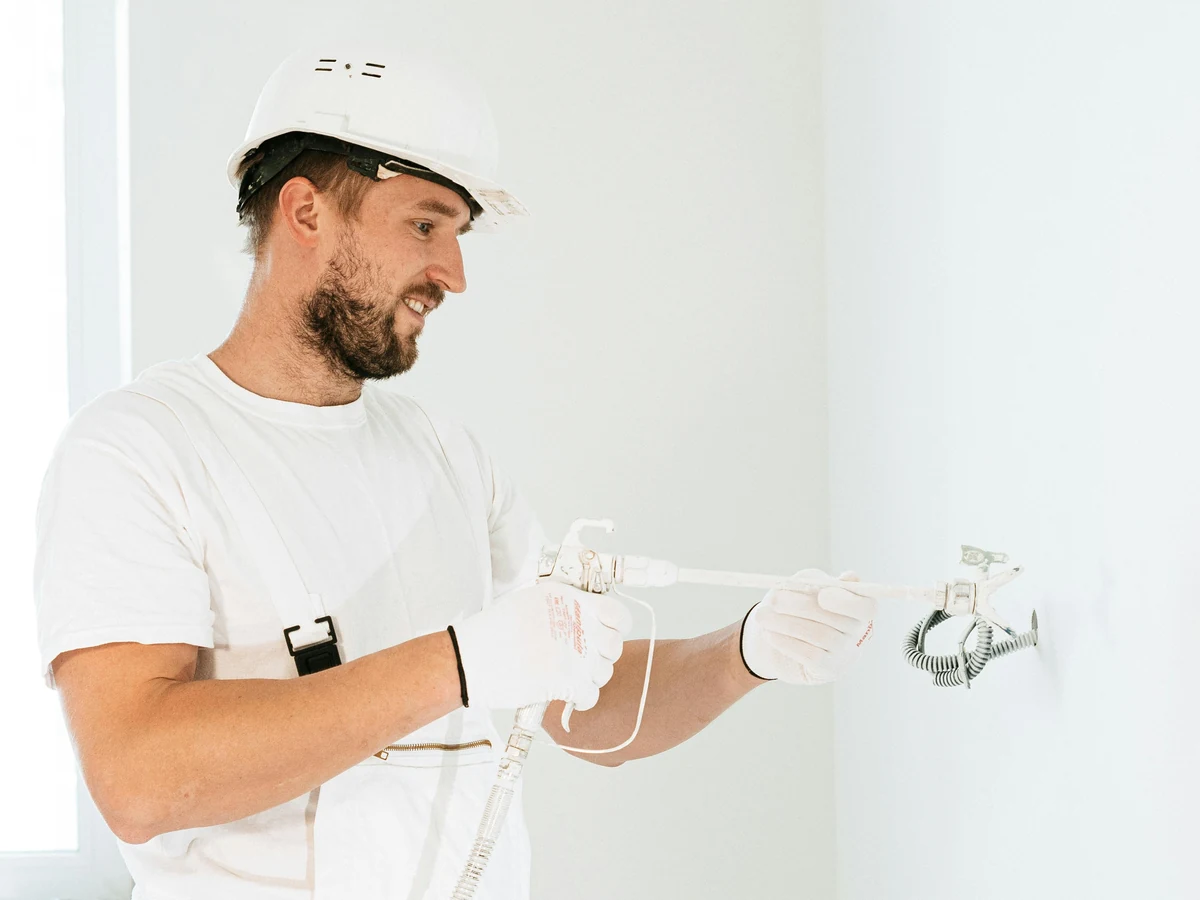 Decorator examining renovation site with hardhat, Richmond Decorators